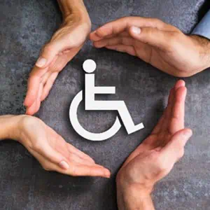 Hands embracing a wheelchair symbol, representing support and inclusivity for individuals with mobility challenges.